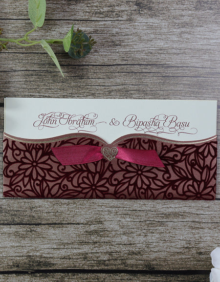 Close-up of SC 5464 Maroon Floral Velvet Pocket Invitation featuring a luxurious maroon ribbon on the front, with intricate floral patterns on a soft velvet texture, showcasing elegance and sophistication. shadicard