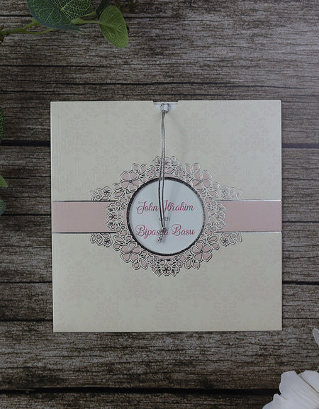 Front view of SC 5657 Square Vintage Cream Damask Floral Pocket Invitation, showcasing a peach background with cream damask floral patterns, silver letterpressed foil, and a circular cutout window from shadi card.com