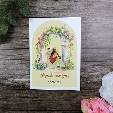 Traditional Indian bride and groom image in wedding clothes under floral arch wedding card