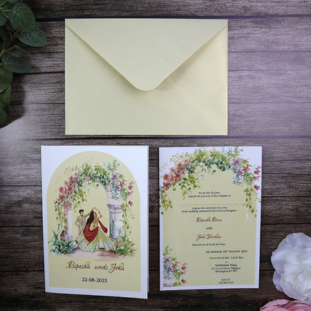 Groom in Sherwani, bride in lehnga dancing under floral arch wedding invitation card