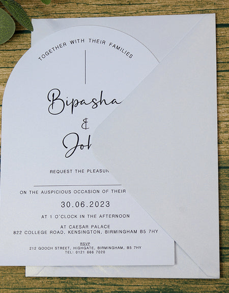 White wedding invite with black text and matching effervescent envelope