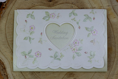 Open view of 7021 Invitation, revealing the heart-shaped cutout with text visible through the light green background and embossed floral patterns on the first fold