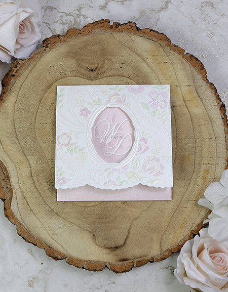 Front view of 7022 Square Pink Invitation, showcasing an embossed pink and green flower pattern and an oblong cutout revealing the letters 'WD' (Wedding Day).