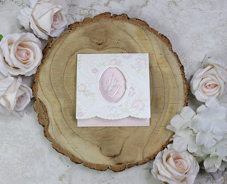 Front view of 7022 Square Pink Invitation, showcasing an embossed pink and green flower pattern and an oblong cutout revealing the letters 'WD' (Wedding Day).