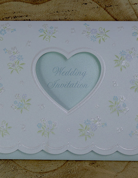 Open view of 7121 Invitation, revealing the heart-shaped cutout with light blue text reading 'Wedding Invitation' and the floral bouquet design on the first fold, perfect for weddings and formal events