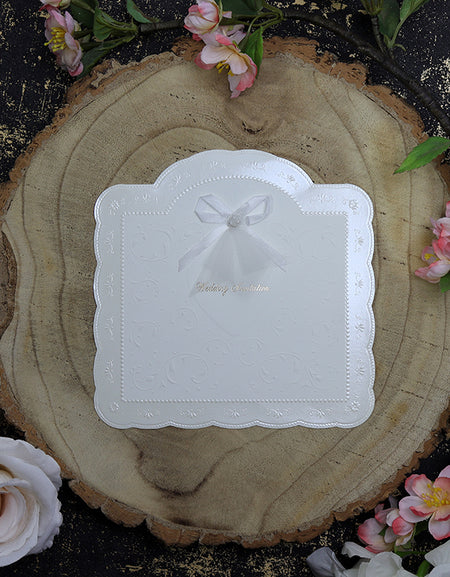 Close-up of BW20 wedding invitation highlighting embossed patterns and delicate white satin and net bow with pearl stud. rosemood .com