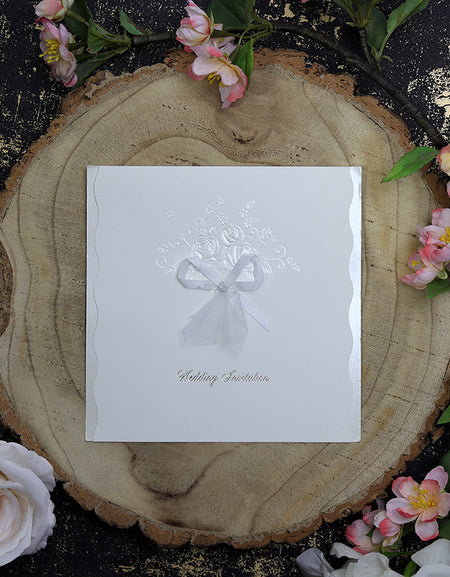 Close-up of BW21 wedding invitation showcasing gold-foiled "Wedding Invitation" text and embossed floral bouquet on off-white cardstock.