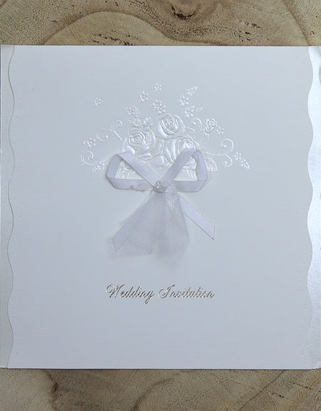Flat-lay of BW21 folded wedding invitation highlighting wavy die-cut edges and elegant hand-tied bow.