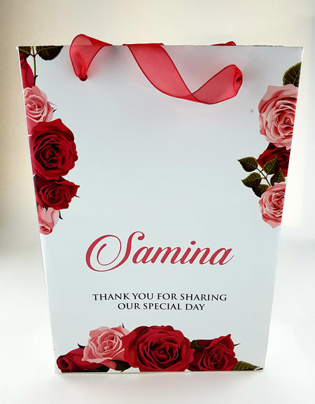 Front view of Personalized Floral Gift Bag 103 featuring a red rose floral border and a sheer red ribbon handle from shadi cards