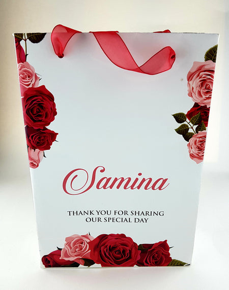 Front view of Personalized Floral Gift Bag 103 featuring a red rose floral border and a sheer red ribbon handle from shadi cards