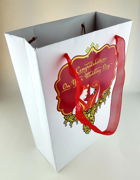 Front view of deep red and gold Mughal-style wedding favor bag with intricate royal emblem