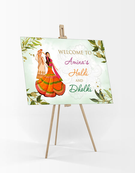 welcome board for haldi ceremony with green leaves and caricaure of Indian bride & groom