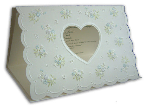 Load image into Gallery viewer, Close-up detail of 7121 Invitation, highlighting the heart-shaped cutout and light blue text visible through the shimmering white pearlescent cardstock, adding a unique and creative touch
